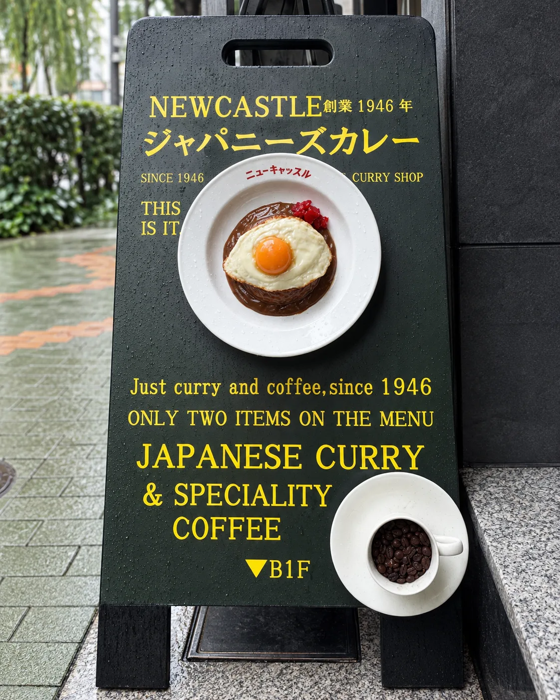 入口の黒緑のA型看板。見本の皿とコーヒーカップ
